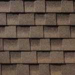 Close-up view of several rows of brown asphalt roof shingles arranged in an overlapping pattern.