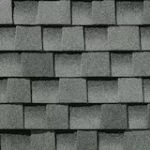 Close-up view of overlapping gray asphalt roof shingles arranged in a staggered pattern, creating a textured surface.