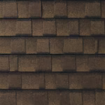 Close-up view of brown, rectangular roof shingles arranged in overlapping horizontal rows. The texture and color variations suggest they are made of asphalt or a similar material.