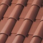 Close-up view of a red clay tiled roof, showing overlapping curved tiles arranged in neat, parallel rows.
