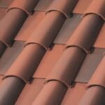 Close-up of overlapping reddish-brown ceramic roof tiles arranged in a repeating pattern, creating a textured surface commonly seen on traditional rooftops.