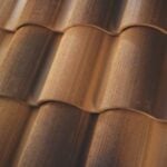 Close-up view of brown, curved ceramic roof tiles arranged in overlapping rows, showing texture and shading.