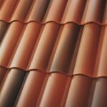 Close-up of red and brown clay roof tiles arranged in a wave pattern, showing texture and repetition under soft lighting.