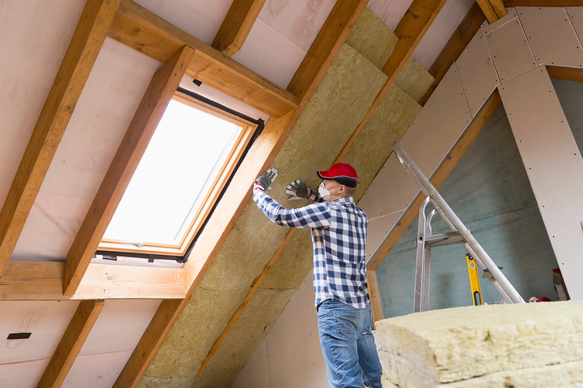 a man installs attic insulation