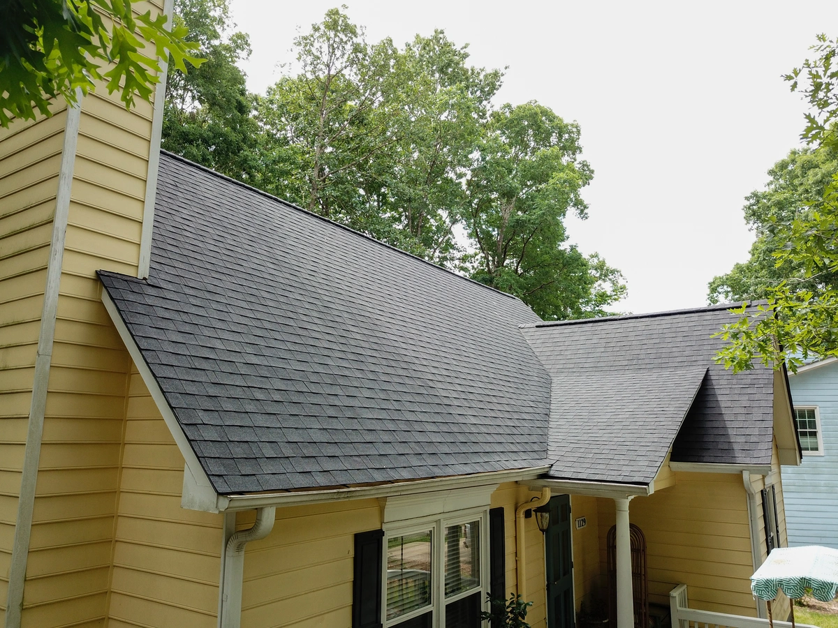 yellow siding house and cleaned roof