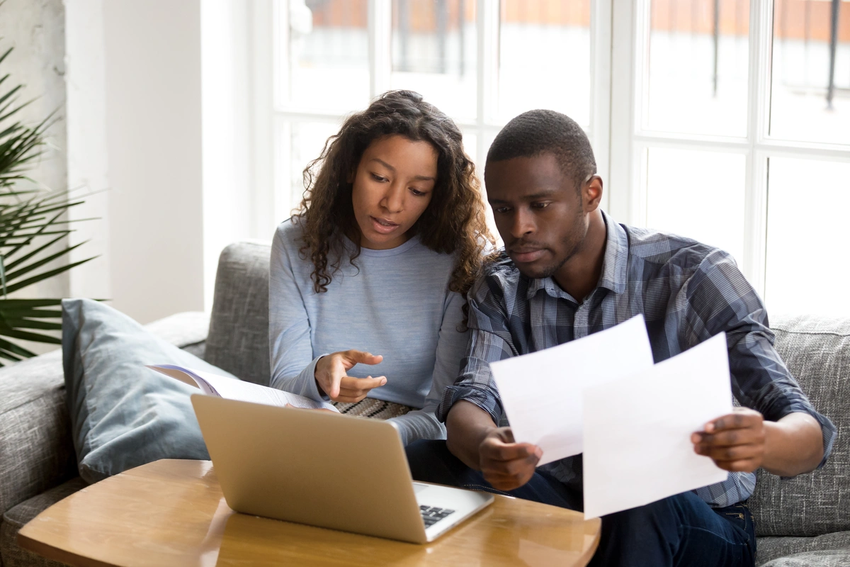 A couple looking at paperwork and a computer