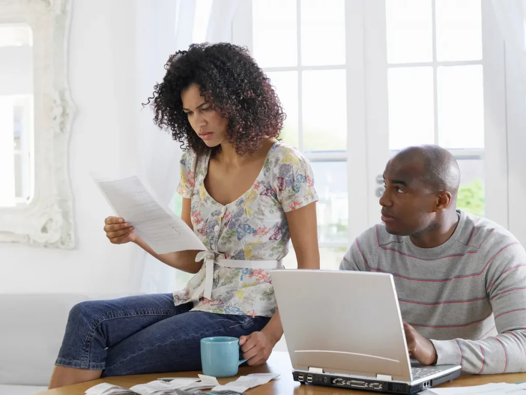 couple with laptops and bills