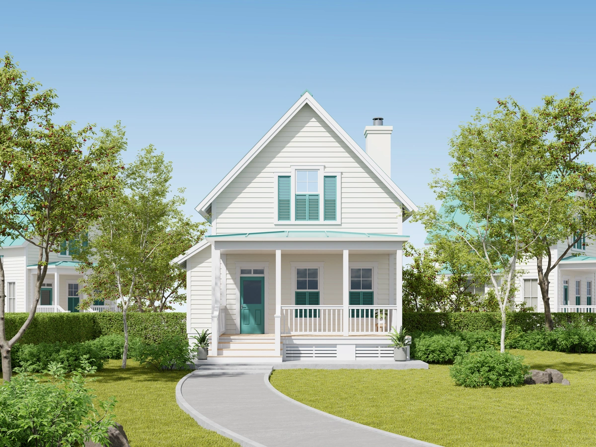 A white, two-story house with a porch and teal front door sits under a clear blue sky. Surrounded by trees and a manicured lawn, its inviting path hints at homeowners who know how to get insurance to pay for your roof replacement when needed.