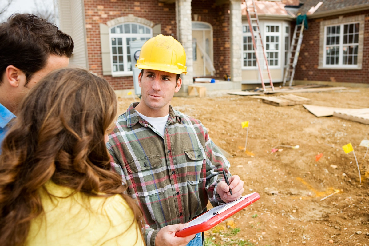 A roofer talks with homeowners