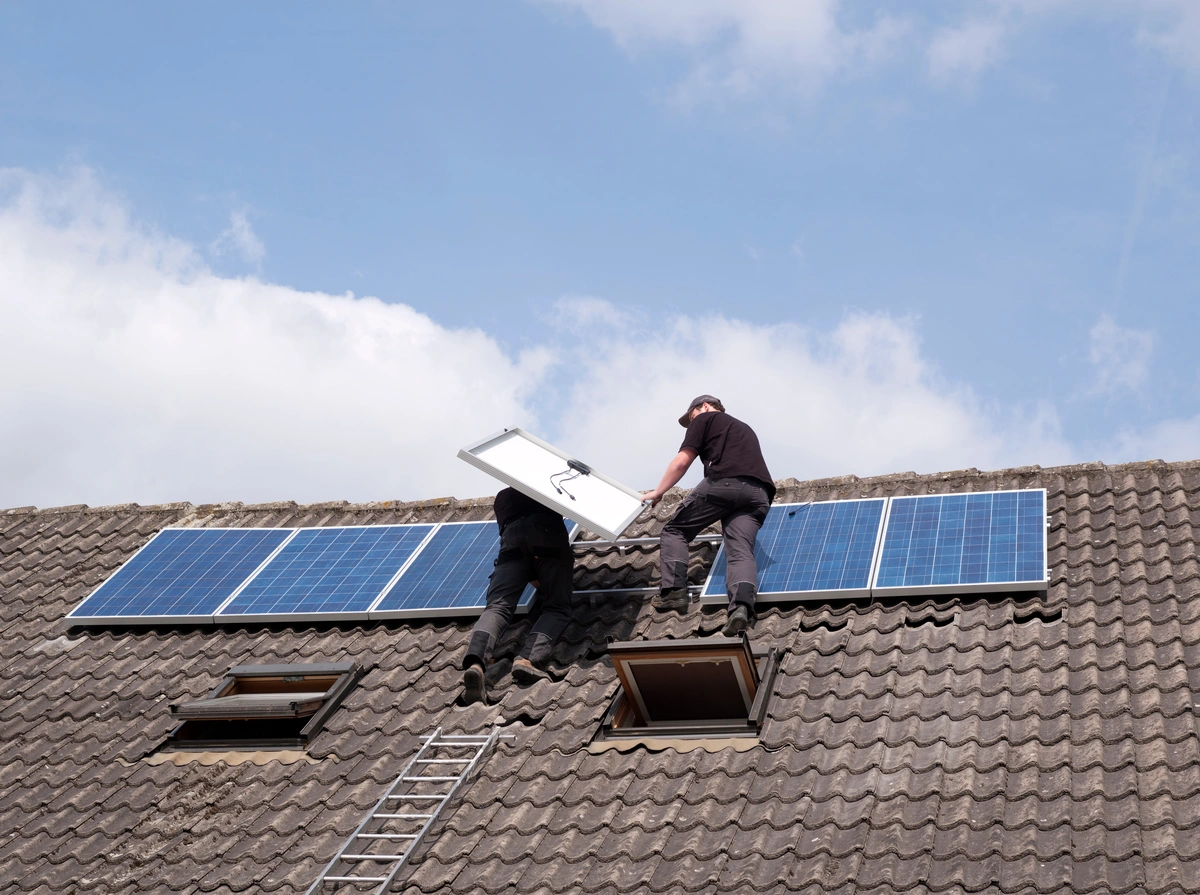 professional roofers placing solar panels 
