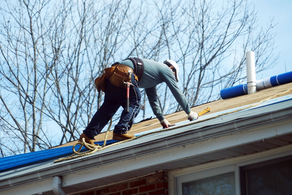 professional worker on the roof installing shingles