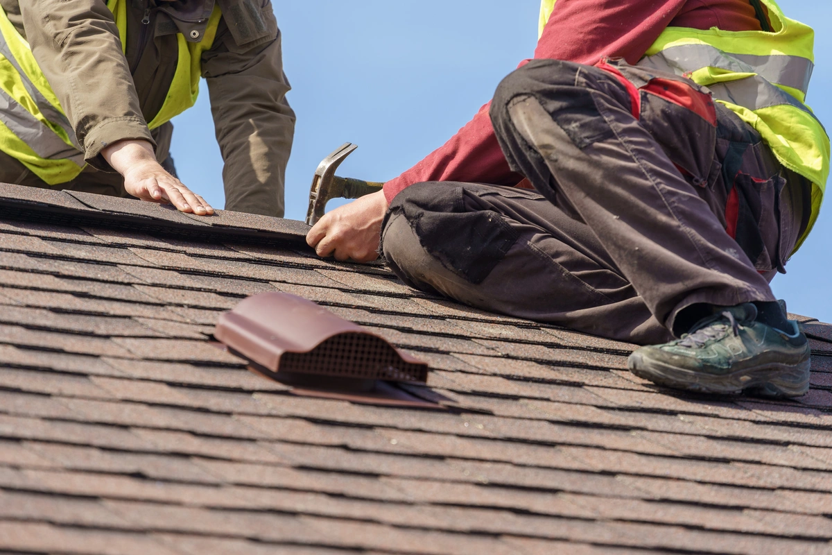 two men repairing the asphalt shingle roof