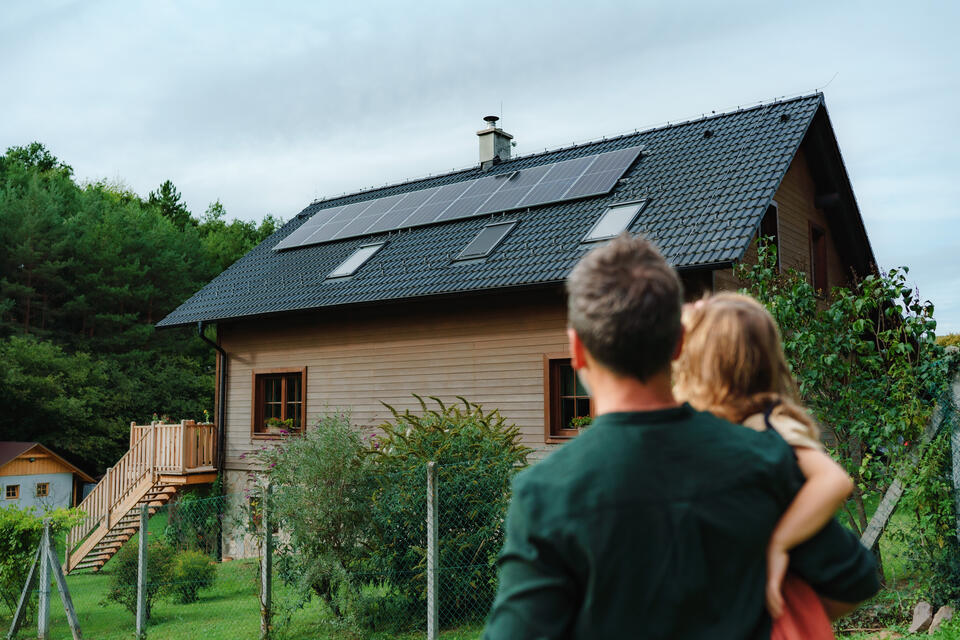 modern roof-dad and daughter looking at their house with new solar panels on roof