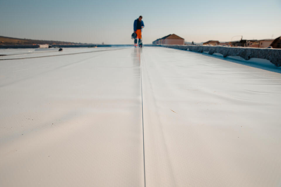 pvc roofing-roofer installing pvc roofing on a large commercial flat roof