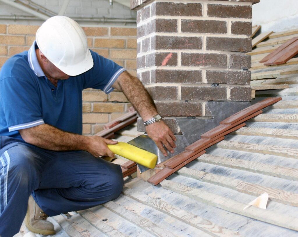 worker installing metal roof flashing