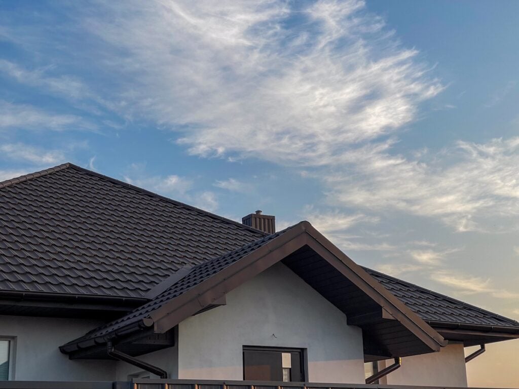 Metal roof design. Roof flashing newly built roof using metal tiles.