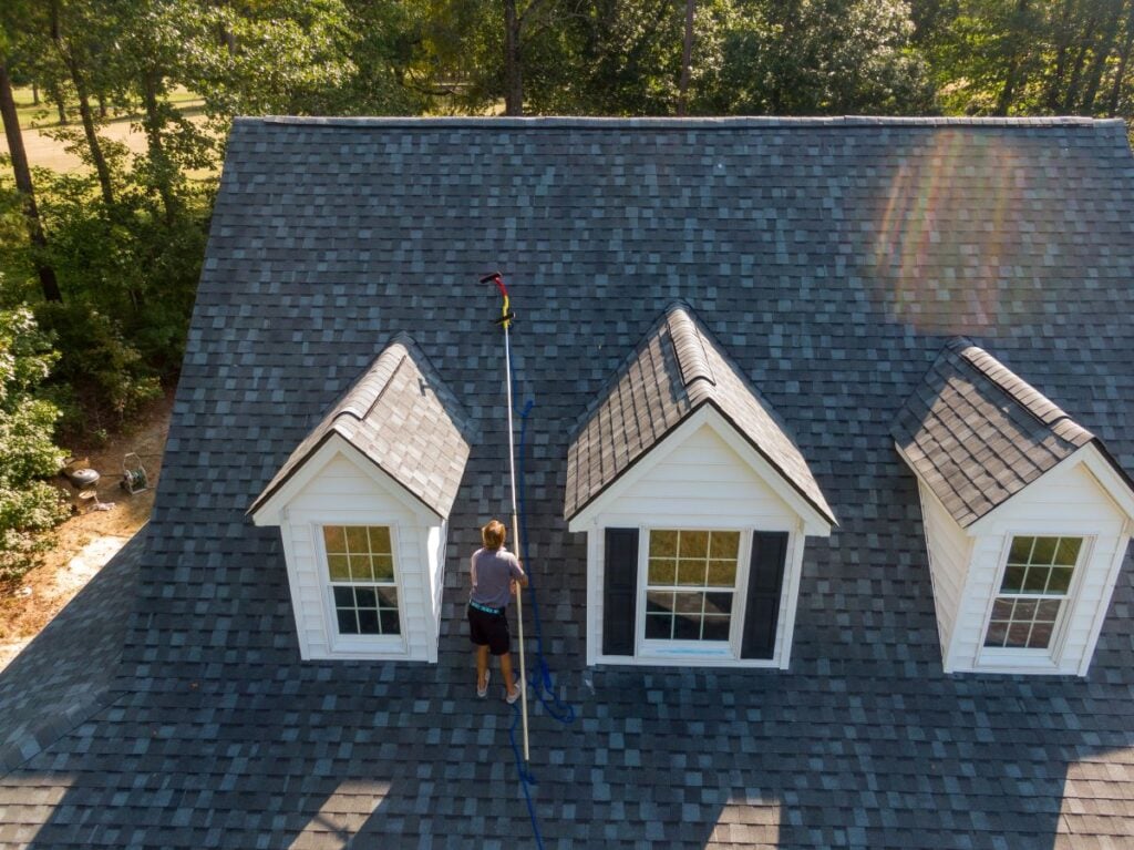 drone roof inspection worker cleaning house shingles grey roof big family home