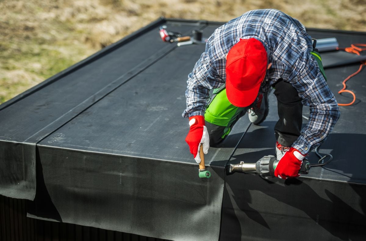 epdm roof repair worker replacing cover in commercial building