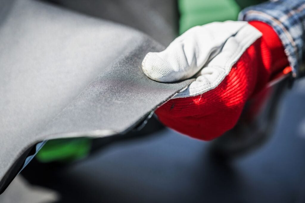 pdm roof sealant worker holding EPDM Ethylene Propylene Diene Terpolymer Material with white and red gloves