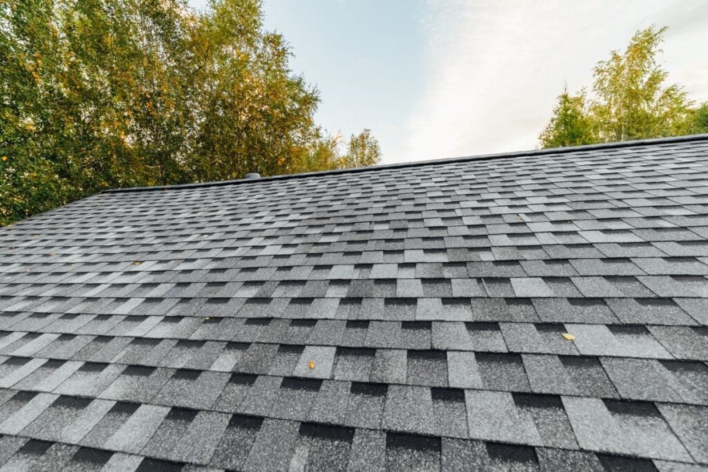 roof replacement cost Wesley chapel grey shingles on big american family house during autumn