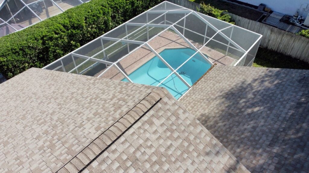 shingle vs metal roofing Wesley mchapel grey shingle roof big house with pool in Florida drone picture